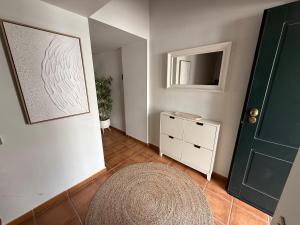 a hallway with a white dresser and a green door at Les Oliveres Beach in Perelló