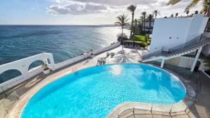 an infinity pool on the top of a building overlooking the ocean at Apartment Monte Del Moro in San Agustin