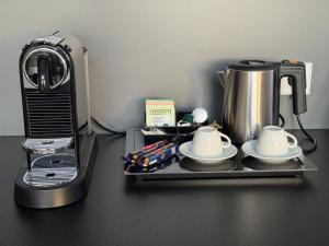 a tray with two cups and a coffee maker at WakeMālpils brīvdienu mājas in Mālpils