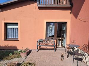 a dog standing next to a bench in front of a building at Przystań nad Dłubnią in Wysocice