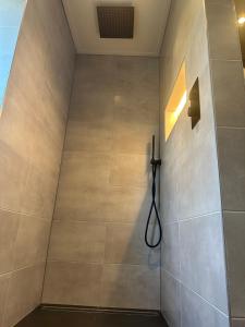 a shower stall in a bathroom with a shower head at Op t hiem in Nes