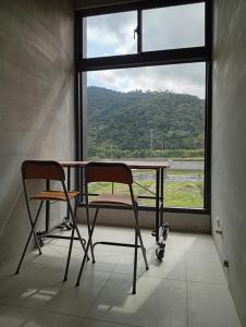 a table and two chairs in front of a window at 宜蘭縣三星鄉遇雨魚民宿2932 in Gongzhao +7 photos