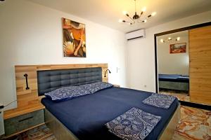 a bedroom with a blue bed with a mirror at Apartments Aurelia in Vodice