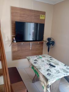 a living room with a table and a flat screen tv at imovel 2 e 3 in Guaratuba