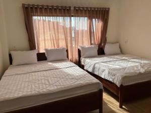two beds in a room with a window at Sola Hòn Sơn in Lai Sơn +5 photos