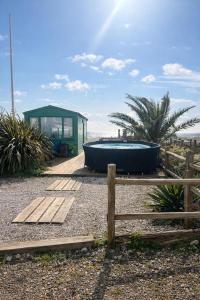 a building with a bath tub next to a fence at Beautiful 4 Bed Beach House in Pevensey