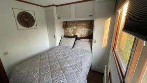 a bedroom with a bed in a small room at Geniet van rust en privacy in onze gezellige chalet op familiecamping De Tien Heugten in Drenthe in Schoonloo