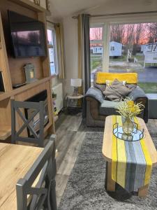 ein Wohnzimmer mit Sofa und Tisch in der Unterkunft Rydal 38 Haven lakeland LA11 7LT in Flookburgh