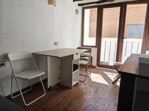 an office with a desk and chairs and windows at Casa Pura de Trevélez in Trevélez