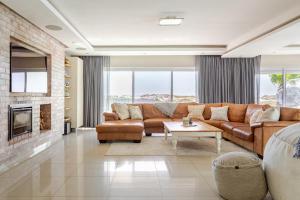 a living room with a couch and a fireplace at Melkbos Beachfront Villa in Cape Town