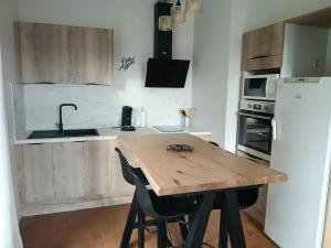 a kitchen with a wooden table and a sink at Gîte rural indépendant in Barbaste