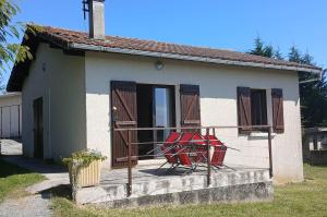 a house with a red chair on a balcony at Gîte rural indépendant in Barbaste