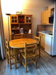 a kitchen with a wooden table and chairs and a refrigerator at Abondance appartement 4 pers in Abondance