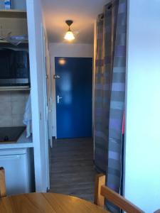 a hallway with a blue door and a table at Abondance appartement 4 pers in Abondance