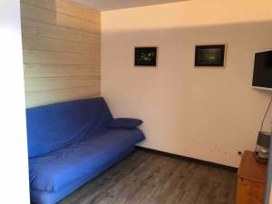 a blue bed in a room with a tv at Abondance appartement 4 pers in Abondance +2 photos