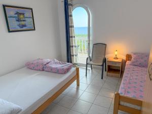 a bedroom with a bed and a table and a chair at Vila Pogled in Petrovac na Moru