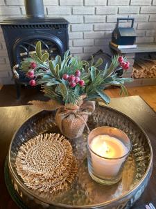a table with a candle and a vase with a plant at Bregnehytte in Leikanger
