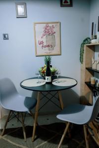 a table with two chairs and a bottle and glasses at Blue Horizon Corinth in Korinthos