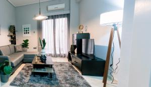 a living room with a couch and a tv at Blue Horizon Corinth in Korinthos