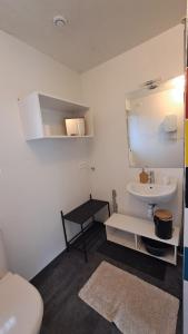 a bathroom with a white sink and a toilet at Le refuge coloré in Gap