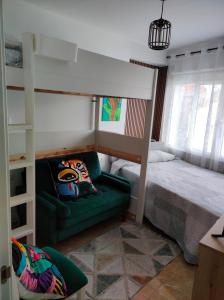 a bedroom with a bunk bed and a green couch at Alojamiento céntrico Ribeira con parking sin ascensor in Ribeira