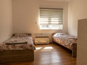 a bedroom with two beds and a window at Villa Mia in Sarajevo