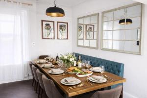 a dining room with a table with chairs and food on it at Beautiful 4 Bed Beach House in Pevensey