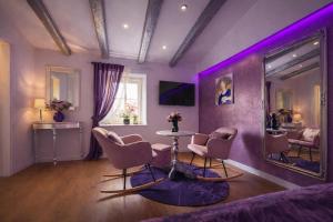 a purple room with a table and chairs and a mirror at Bed&Breakfast Andio in Dubrovnik