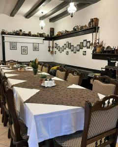 a long table in a restaurant with white tablecloths at Pensiunea Mugur De Fluier in Vama +69 photos