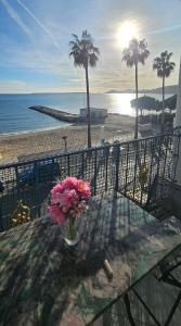 a vase of flowers sitting on a table near the beach at Le Reflet d'Azur - les pieds dans l'eau in Antibes