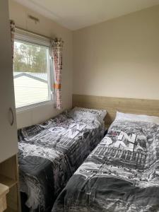 two beds sitting next to each other in a bedroom at Caravan Holiday Park in Newquay in Newquay
