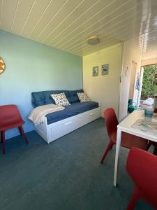 ein Schlafzimmer mit einem Bett, zwei Stühlen und einem Tisch in der Unterkunft Hof van Axel, stacaravan 26, 28, pipowagen Bosuil of Zeemeeuw in Axel