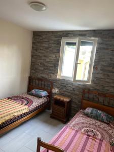 a bedroom with two beds and a window at Home stay Spacious room in Massy