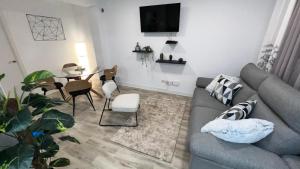 a living room with a gray couch and a table at Villamadrid Home in Madrid +9 photos