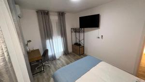 a room with a bed and a television on a wall at Villamadrid Home in Madrid