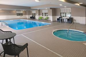 a pool in a hotel room with chairs and a table at Hampton Inn Lima in Lima