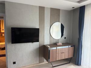 a living room with a television and a mirror at Forest Panorama Luxury Apartment in Velingrad