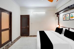 a bedroom with a large white bed and a door at HOTEL O 4 SQUARE A LUXURY ROOMS NEAR RDC MAIN MARKET in Ghaziabad