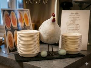 a chicken sitting on a table next to stacks of plates at Hôtel Restaurant Aux Deux Roses in Neuf-Brisach