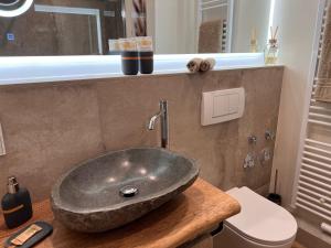 a bathroom with a stone sink on a counter at Palazzo Moni - Modernes Studio in der Nähe der Therme mit Balkon & Parkplatz in Bad Soden-Salmünster +11 photos
