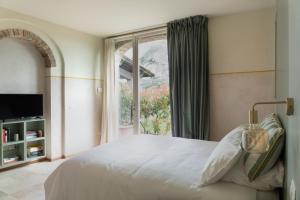 a bedroom with a bed and a large window at I Casciani in Montespertoli