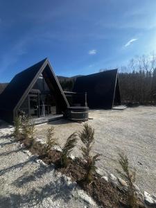 a large black building with trees in front of it at A-frame Boema in Cîmpu lui Neag
