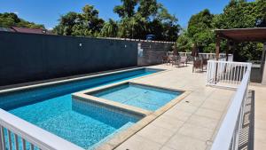 a swimming pool with blue water in a backyard at Apartamento 2 quartos Blumenau a 10 minutos da Vila Germânica in Blumenau
