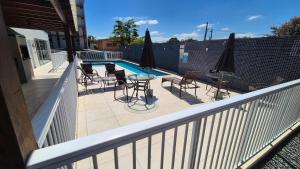 a balcony with a table and chairs and a pool at Apartamento 2 quartos Blumenau a 10 minutos da Vila Germânica in Blumenau