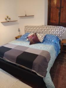 a bedroom with a bed with a black and white comforter at Villa Paradiso Julia in Dicomano