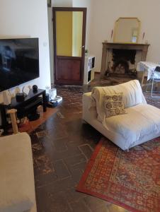 a living room with a white couch and a flat screen tv at Villa Paradiso Julia in Dicomano