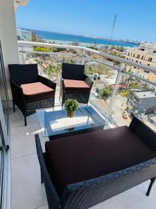 a balcony with tables and chairs and a view of the ocean at The Perfect Place to be in Boca Chica