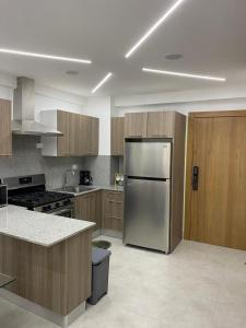 a kitchen with a stainless steel refrigerator and wooden cabinets at The Perfect Place to be in Boca Chica
