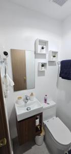 a white bathroom with a toilet and a sink at The Perfect Place to be in Boca Chica +16 photos