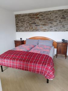 a bed with a red plaid blanket and two night stands at Come a casa B&B in Montegrino Valtravaglia